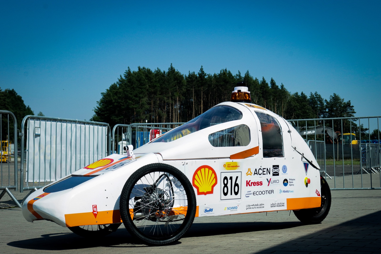 A white, streamlined student-built car numbered 816 at an outdoor track, covered in sponsor logos including Yuro.